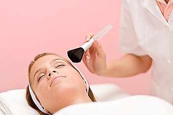 Luxury facial care - woman in spa salon with beautician receiving beauty treatment