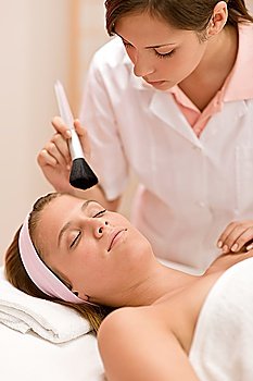 Luxury facial care - woman in spa salon with beautician receiving beauty treatment