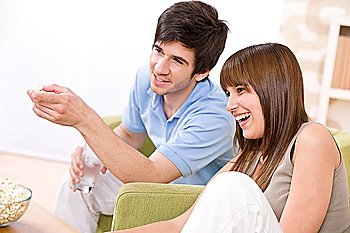 Student - happy teenagers watching television in living room
