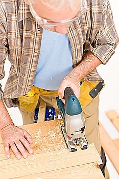 Home improvement - handyman cut wood with jigsaw in workshop
