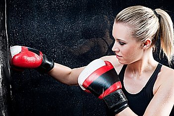 Boxing training woman with punching bag in gym wear gloves