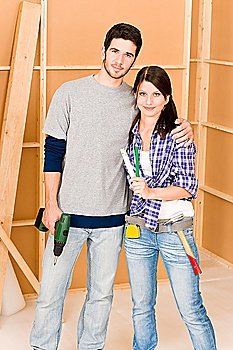 Home improvement young happy couple with repair tool hand drill ruler