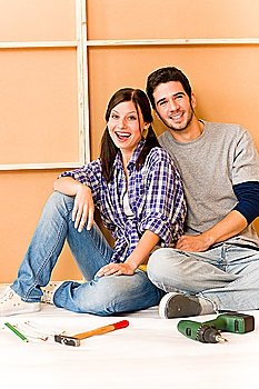Home improvement young cheerful couple repair tool relax on floor