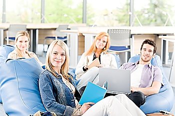Portrait of high-school study group with laptop sitting together