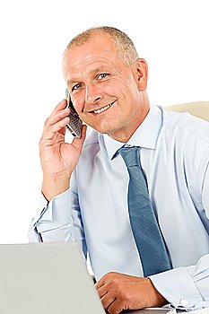 Portrait of successful smiling businessman sitting behind table