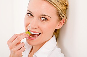 Healthy lifestyle - portrait of woman bite grape on white background