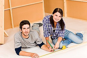 Home improvement young happy couple working on floor renovations