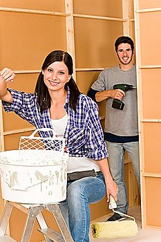 Home improvement: young happy couple fixing new house renovating wall