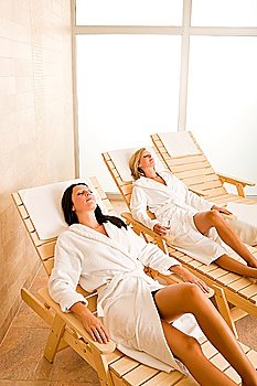 Spa luxury relax room two beautiful women lying on sun-beds
