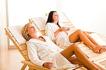 Relax luxury spa beauty women enjoy refreshments lying on sun-beds