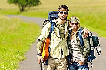 Hiking young couple backpack tramping on asphalt road sunny countryside