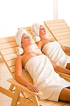 Spa luxury relax room two beautiful women lying on sun-beds