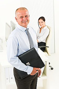 Professional senior businessman hold briefcase in office with attractive secretary