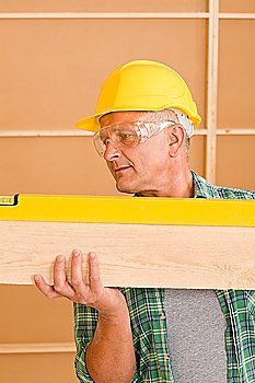 Handyman mature professional with spirit level working on home renovations