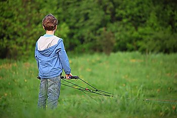 behind boy ready to kite fly on meadow