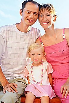 Happy family with little girl on beach