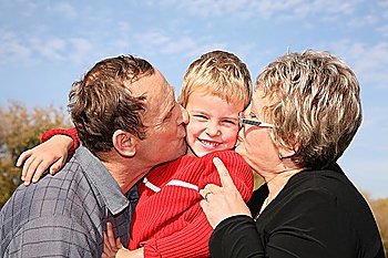 grandmother and grandfather kiss the grandson