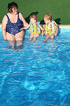 The grandmother and children sit at pool.