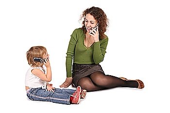mother and daughter sitting they talk on the cell phones on the the white