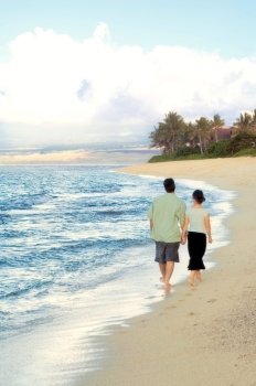 Man and Woman Walking Hand in Hand on Beach