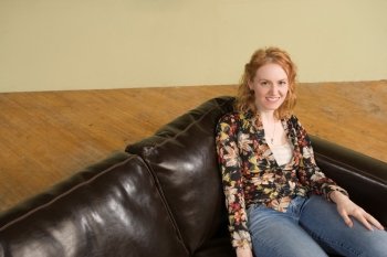 Woman Sitting in Corner of Couch