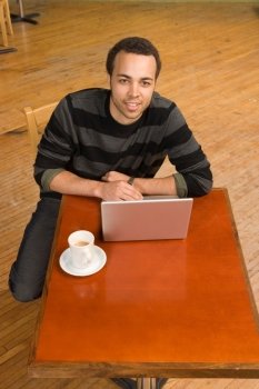 Young Man Computing at Table