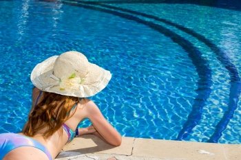 Woman in straw hat near the pool
