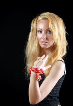beautiful young woman with long  blonde hair and a red bracelet on a dark background  