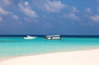 Maldives. A modern boat and a national boat  at ocean