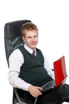 The happy schoolboy in office armchair, with the laptop
