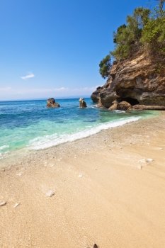 View from a sandy beach on rocks at ocean. Indonesia, Bali  