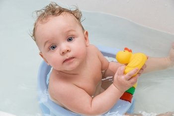beauty baby boy in bath with yellow rubber duck