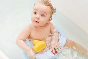 beauty baby boy in bath with toys