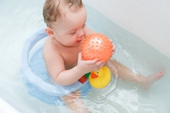 beauty baby boy in bath with rubber ball