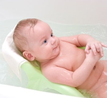 Beauty baby boy having bath at bathing stand