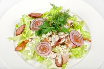 Tasty salad dish close up with sausage and vegetables on a white background