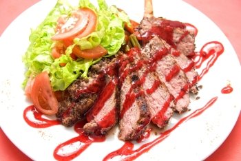 Roasted Beef meat at cranberries sauce with vegetables