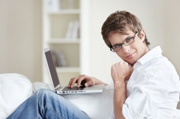 A nice young man with a laptop at home