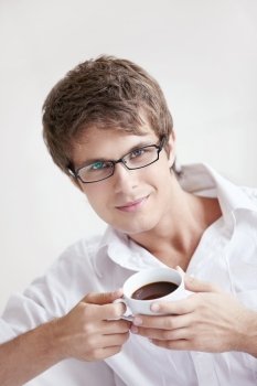 Attractive young man holding a cup of coffee