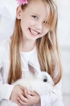 The little girl holding a white rabbit