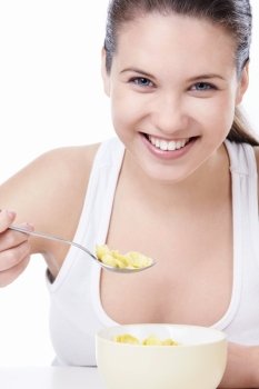 Attractive woman eating corn flakes on a white background