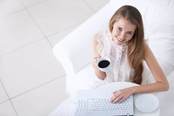 Attractive young girl with coffee and laptop