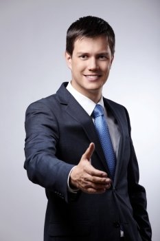 Young businessman in a suit holds out his hand for a handshake
