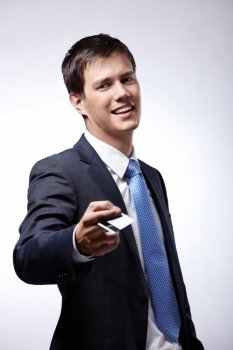 A young businessman holds out a credit card