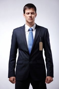 Serious businessman wearing a suit with the tag in pocket