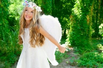 Angel children girl open arms in forest with white wings and flowers crown