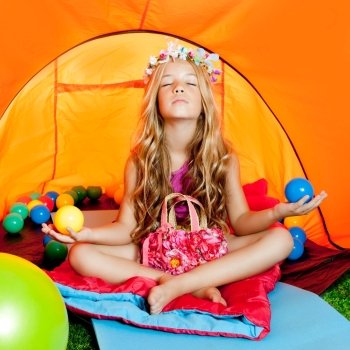 Children girl inside camping tent relaxing with yoga open arms and balls
