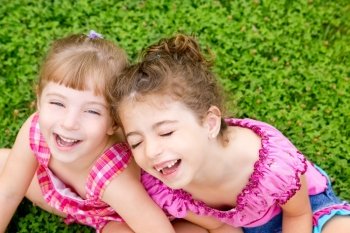 children girls laughing sitting on green grass park