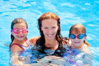 daughters and mother family swimming in pool on summer vacation