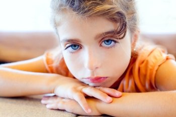 Blue eyes sad children girl crossed arms on table